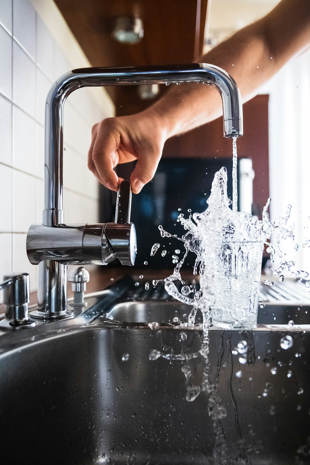 Plumber fitting a modern kitchen tap